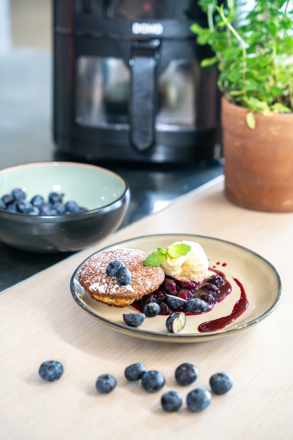 Muffin van witte chocolade met coulis van blauwe bessen